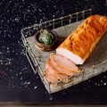 Smoked Canadian bacon with lean slices fanned out from the whole piece on a metal serving tray