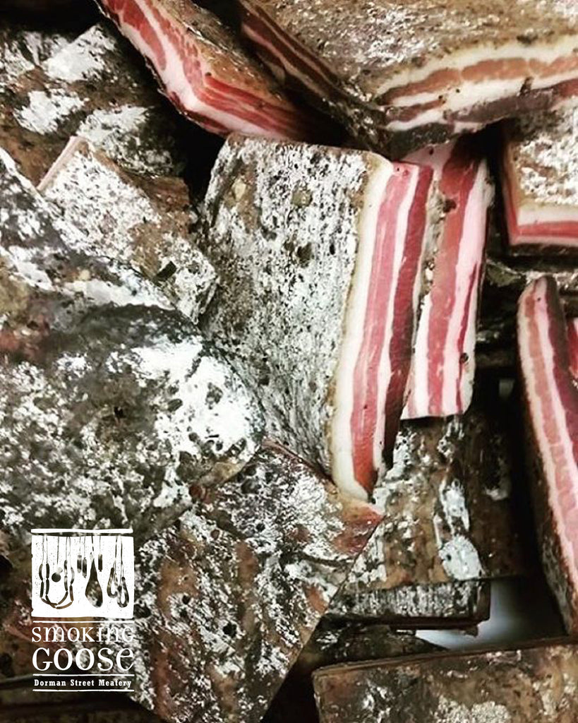 Sliced pancetta tesa showing layers of fat and lean